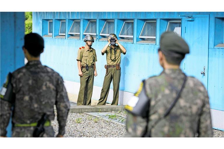 Nordkoreanische Soldaten beobachten südkoreanische Soldaten an den Blauen Baracken der demilitarisierten Zone in Panmunjeom/Korea.