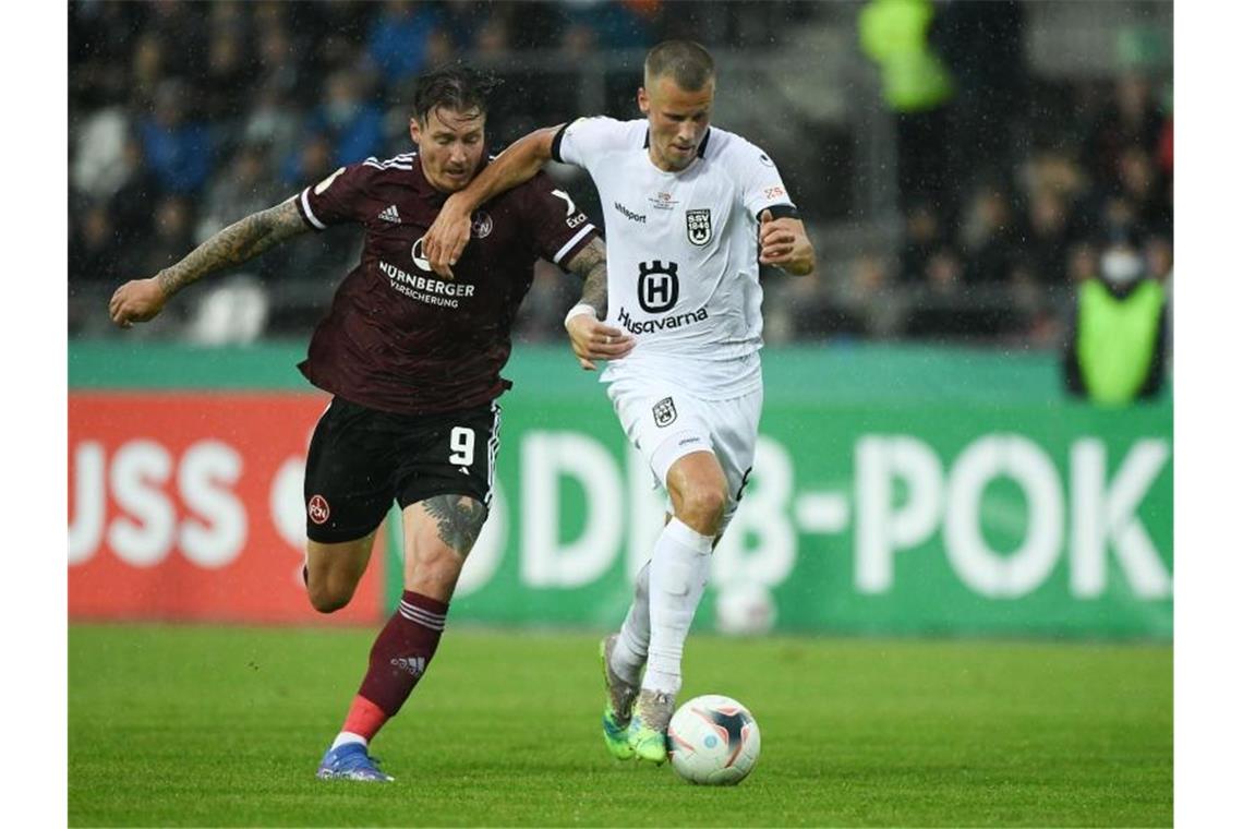 Nürnbergs Manuel Schäffler (l) und Ulms Adrian Beck kämpfen um den Ball. Foto: Silas Stein/dpa