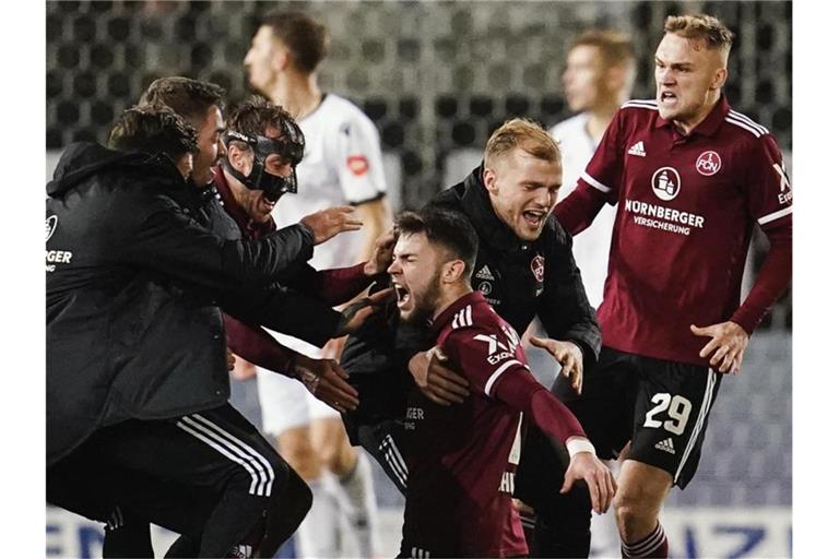 Nürnbergs Torschütze Erik Shuranov (M) jubelt mit Mannschaftskollegen über das Tor zum 1:2. Foto: Uwe Anspach/dpa