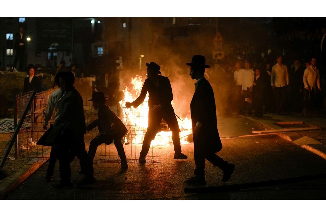 Nun brennen Mülltonnen: Ultraorthodoxe jüdische Männer wehren sich auf einer Demo in Jerusalem gegen eine geplante Rekrutierung als Soldaten. Der Oberste Gerichtshof Israels hat die Regierung angewiesen, die ultraorthodoxe Männer einzuberufen.