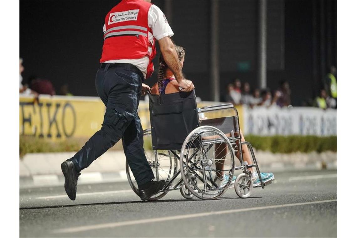 Hindernisläuferin Krause holt WM-Bronze und Rekord Nur 40 der 68 gestarteten Teilnehmerinnen kamen beim Marathon in Doha ins Ziel: Ein Sanitäter bringt eine erschöpfte Läuferin von der Strecke. Foto: Michael Kappeler