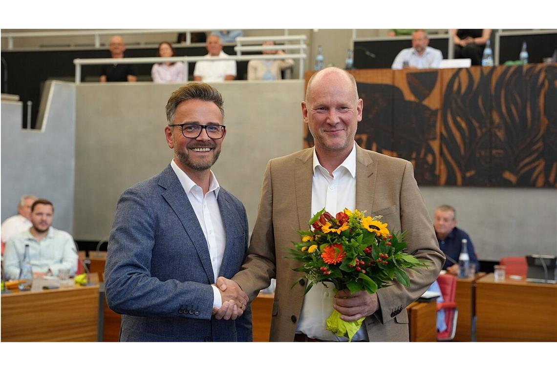 OB Peter Boch (links) gratuliert seinem neuen und alten Stellvertreter Dirk Büscher mit einem Blumenstrauß.