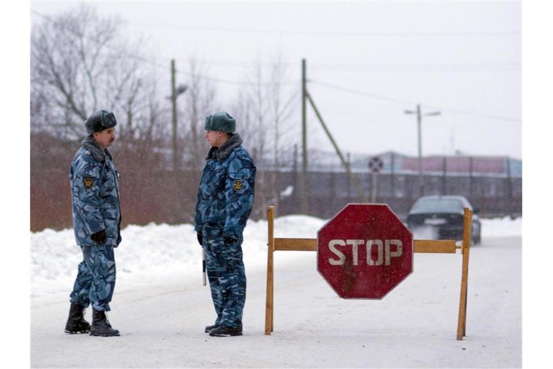 Hölle auf Erden - Straflager wartet auf Kremlgegner Nawalny Offiziere der Spezialpolizei OMON stehen an einer Straßensperre unweit einer Strafkolonie in der Region Karelien. Foto: Kvitkevich Sergey/ITAR-TASS/dpa