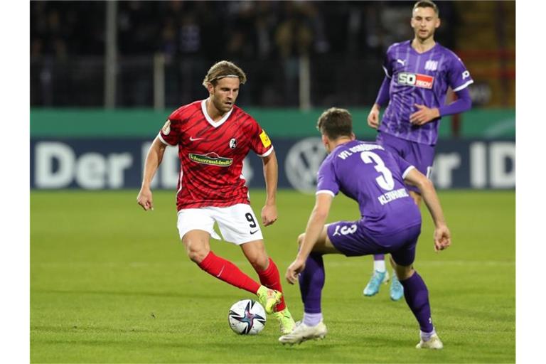 Osnabrücks Florian Kleinhansl (r) im Kampf um den Ball mit Freiburgs Lucas Höler (l). Foto: Friso Gentsch/dpa