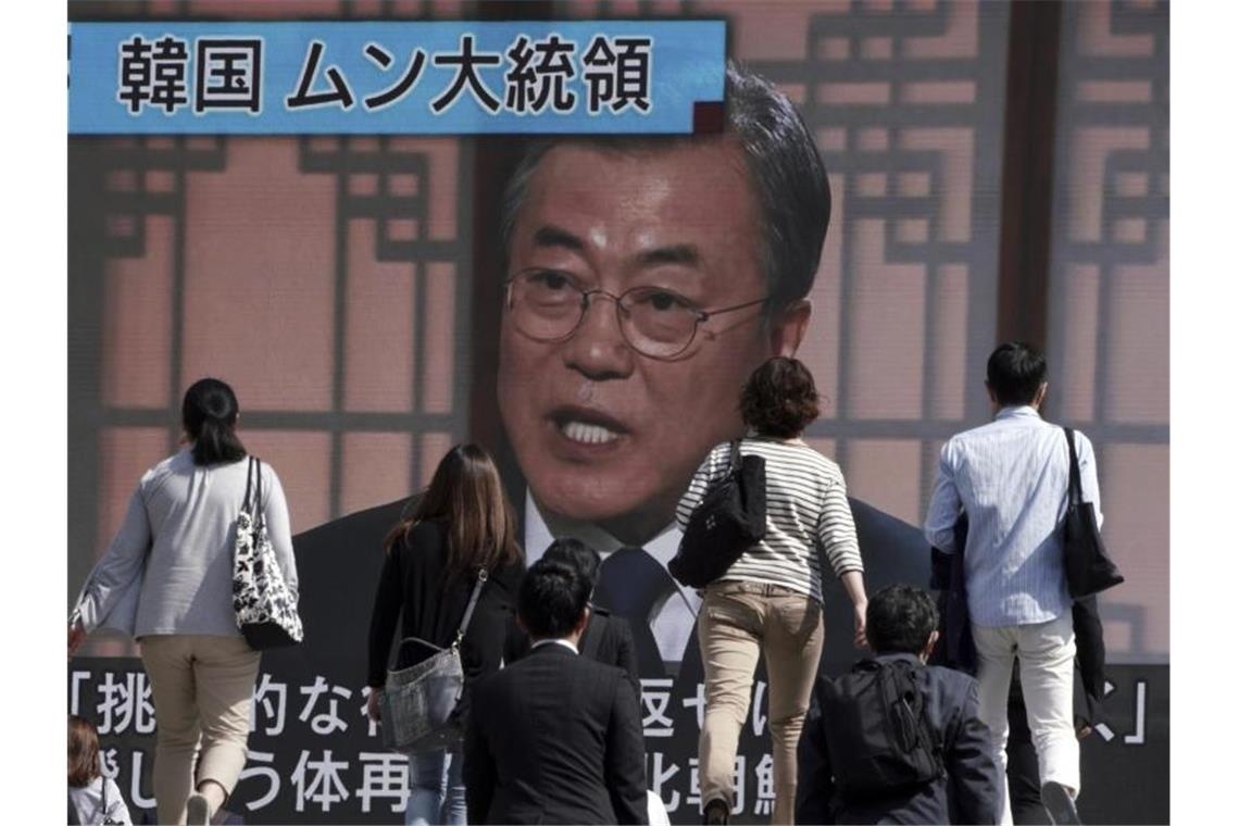 Nordkorea spricht nach neuem Raketentest von Angriffsübung Passanten gehen an einem Bildschirm vorbei, auf dem eine Nachrichtensendung mit dem südkoreanischen Präsidenten Moon Jae-in zu sehen ist. Der südkoreanische Präsident Moon forderte Nordkorea auf, von Handlungen Abstand zu nehmen, die die Diplomatie behindern könnten. Foto: Eugene Hoshiko/AP