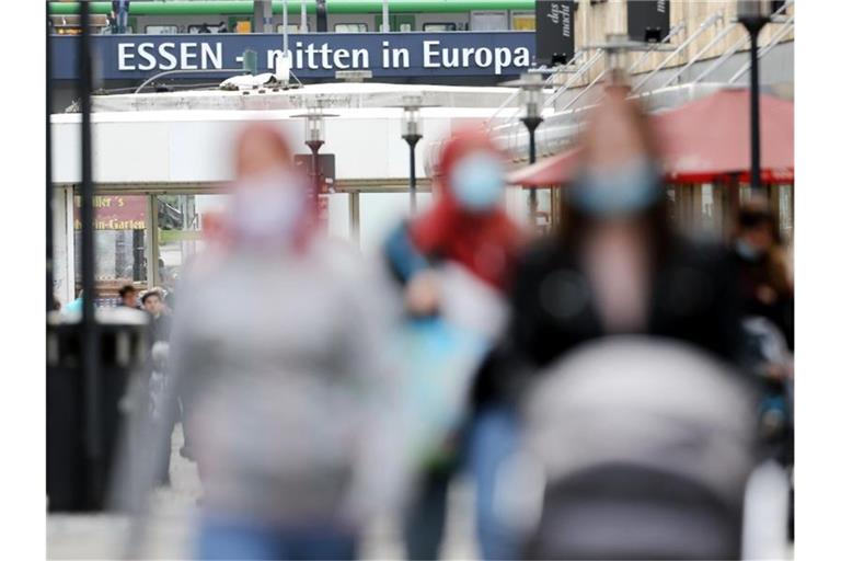 Passanten gehen durch eine Einkaufsstraße in Essen. Foto: Roland Weihrauch/dpa