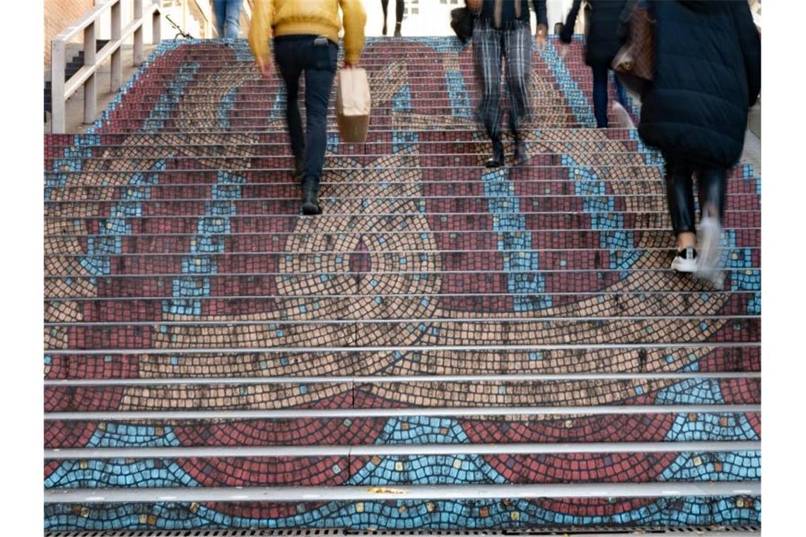 Passanten laufen auf einer Treppe. Foto: Bernd Weißbrod/dpa/Archivbild