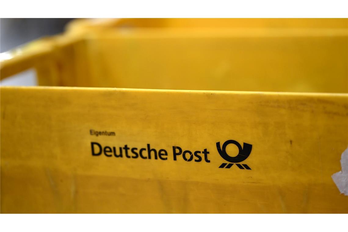 Plastikboxen der Deutschen Post stehen in einer Zustellbasis herum - auch dort könnte der Warnstreik Auswirkungen haben.