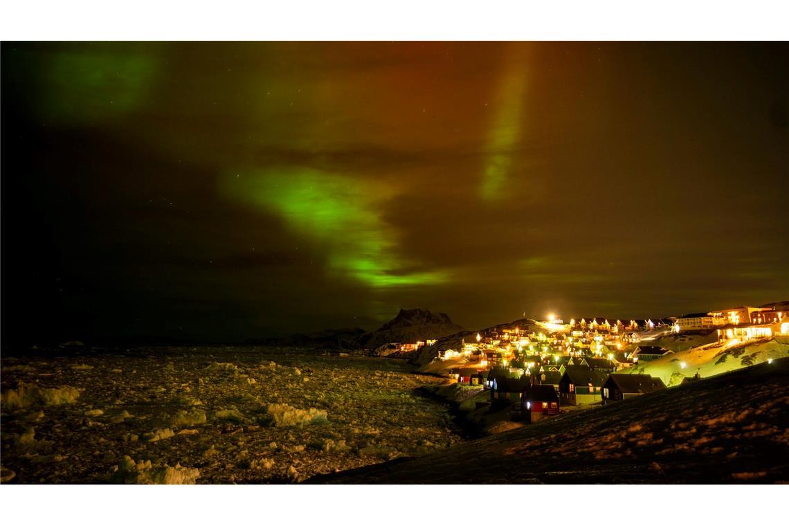 Polarlichter leuchten am frühen Donnerstagmorgen am Himmel über Häusern in Nuuk, Grönland.