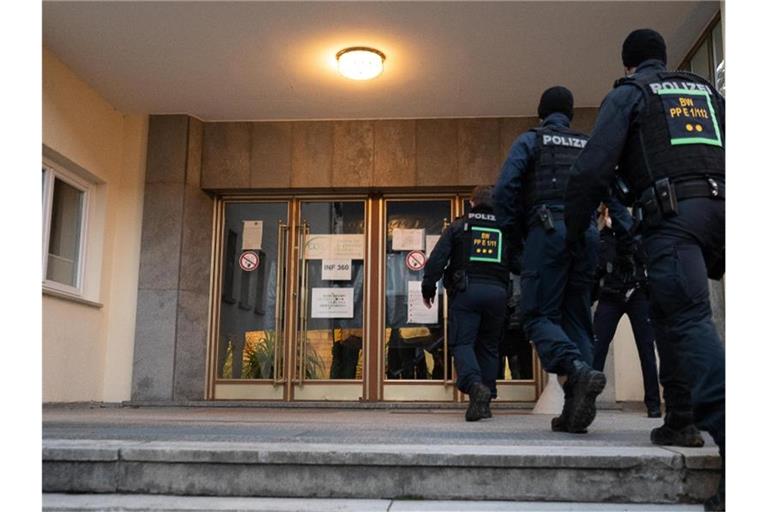 Polizeibeamte betreten auf dem Gelände der Heidelberger Universität das Gebäude, in dem sich der Tatort eines Amoklaufes befindet. Foto: Sebastian Gollnow/dpa