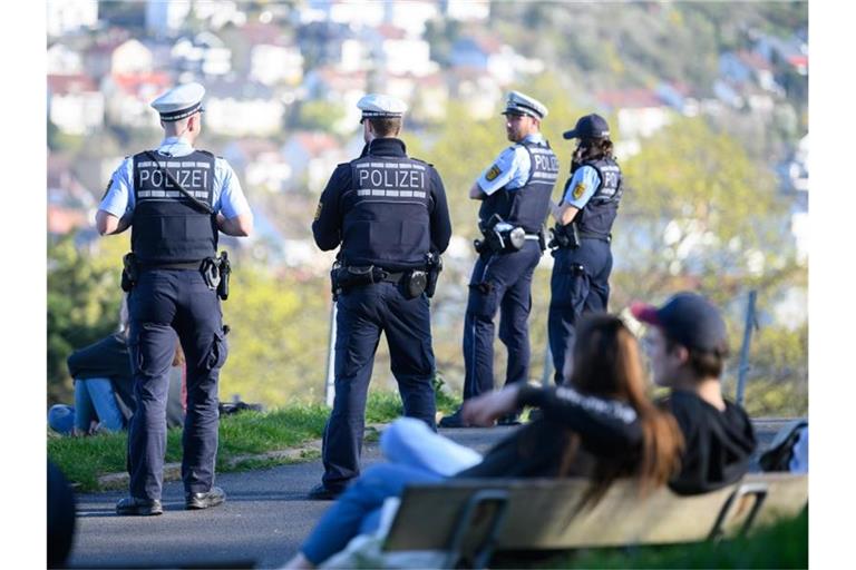 Polizeibeamte kontrollieren auf der Karlshöhe, einem beliebten Park im Süden der Stadt, die Einhaltung der Vorschriften zur Eindämmung des Coronavirus. Foto: Sebastian Gollnow/dpa/Archivbild