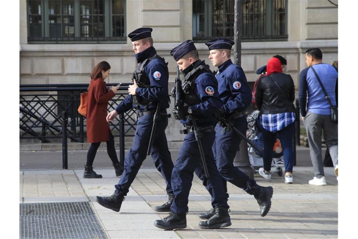 Polizeibeamte patrouillieren mit Gewehren vor dem Pariser Polizeipräsidium. Foto: Michel Euler/AP/dpa