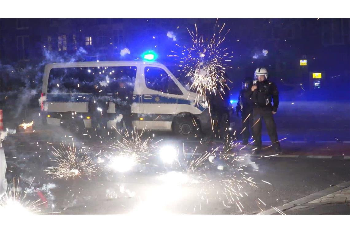 Polizeibeamte stehen am Silvesterabend hinter explodierendem Feuerwerk. (Archivbild)