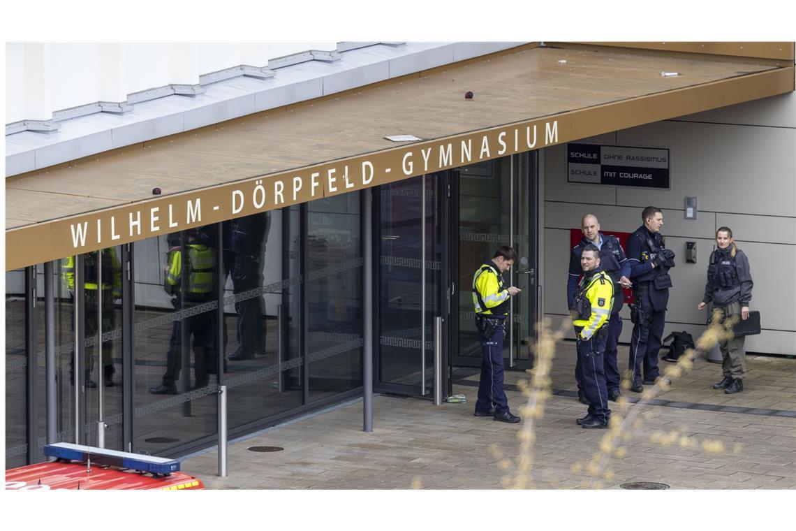 Polizeibeamte stehen vor dem Wilhelm-Dörpfeld-Gymnasium in Wuppertal. Hier sind am 22. Februar  mehrere Schüler schwer verletzt worden.
