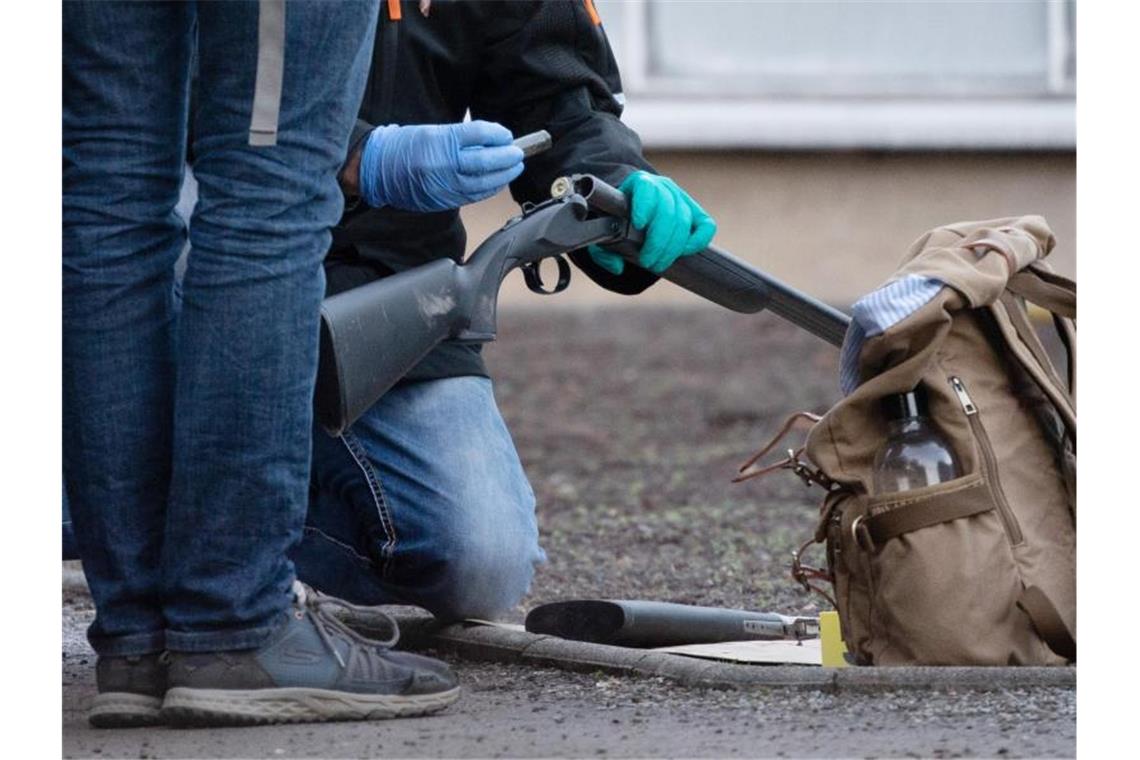 Polizeibeamte untersuchen eine Waffe auf dem Gelände der Universität in Heidelberg. Foto: Sebastian Gollnow/dpa