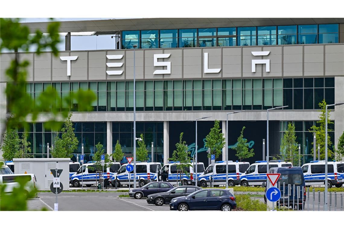 Polizeifahrzeuge stehen am Samstagvormittag vor dem Haupteingang des Tesla-Werks in Grünheide.