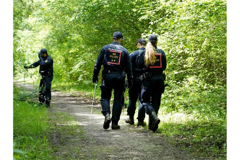 Polizisten durchsuchen die Umgebung des Fundortes einer Frauenleiche nach Spuren. Foto: Benedikt Spether