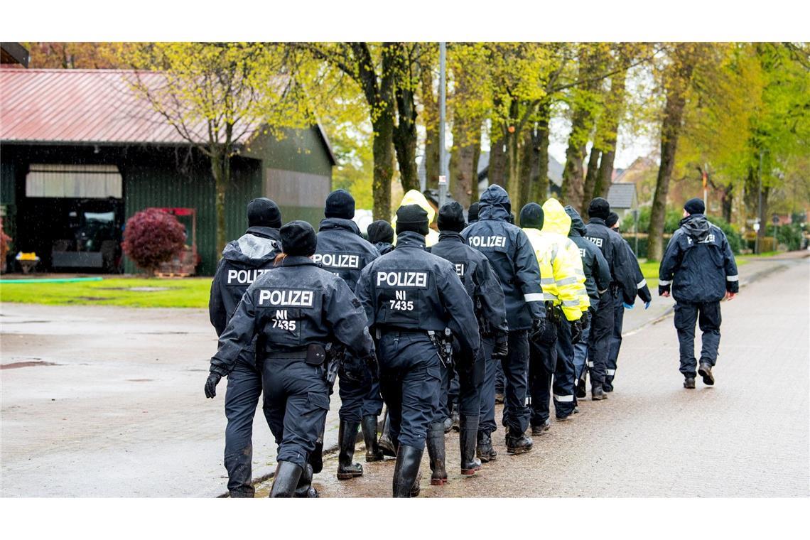 Polizisten gehen auf der Suche nach einem vermissten Jungen durch eine Ortschaft in Niedersachsen.