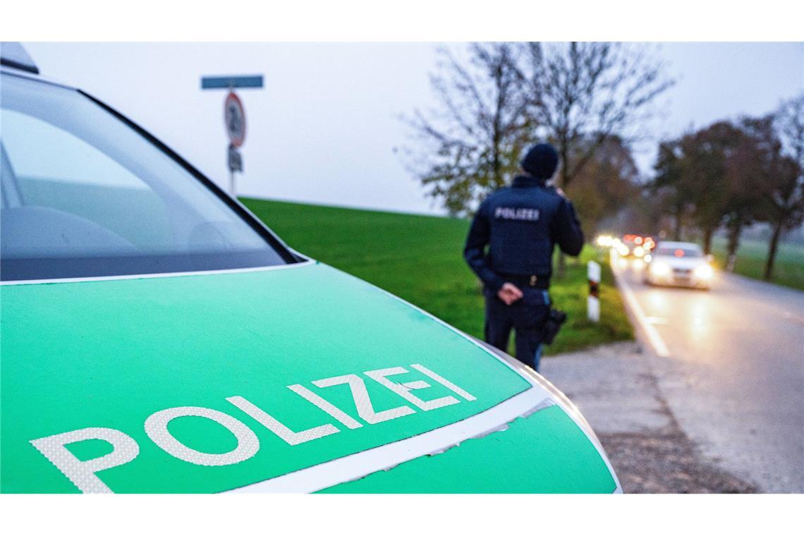 Polizisten haben die Zufahrtsstraße zum Tatort gesichert.