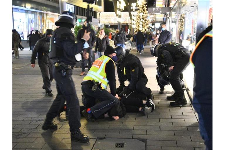 Polizisten in Schutzausrüstung ringen einen Protestierer zu Boden. Foto: René Priebe/PR-Video/dpa