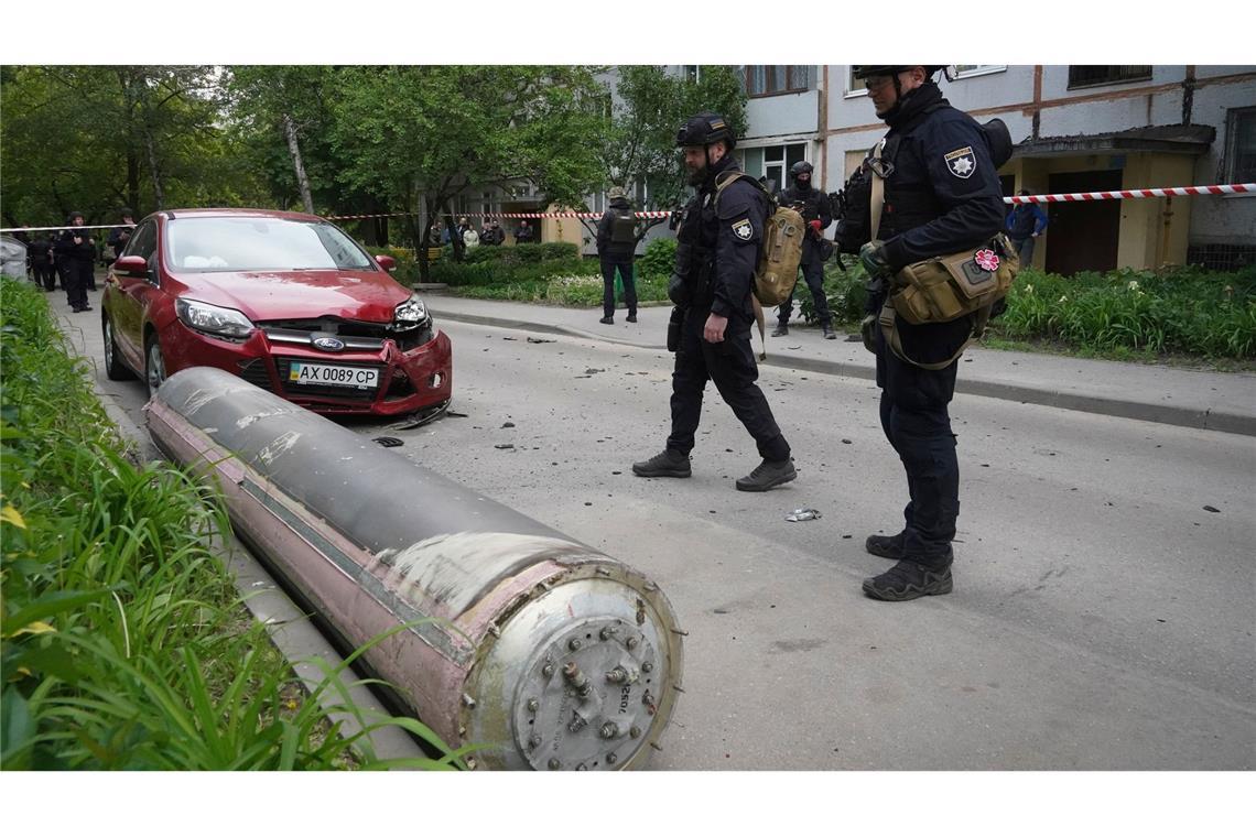 Polizisten inspizieren einen Teil einer russischen Rakete, die in der Nähe eines Wohnhauses in Charkiw eingeschlagen ist.