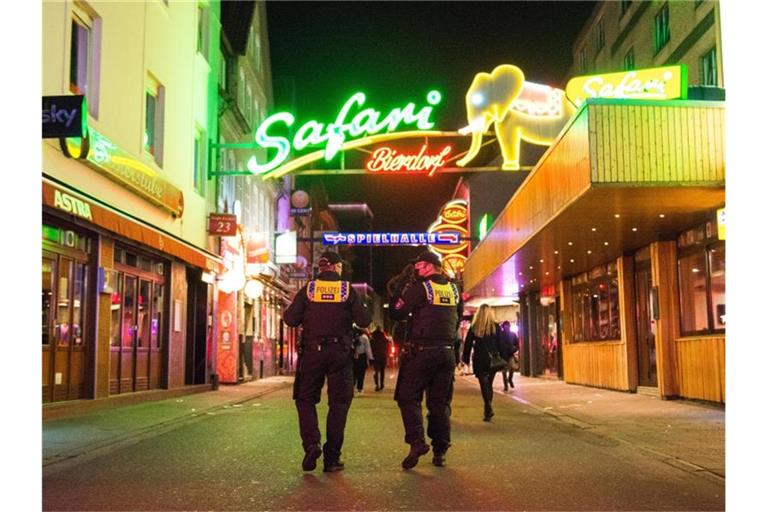 Polizisten kontrollieren die Sperrstunde auf der Reeperbahn. Foto: Daniel Bockwoldt/dpa