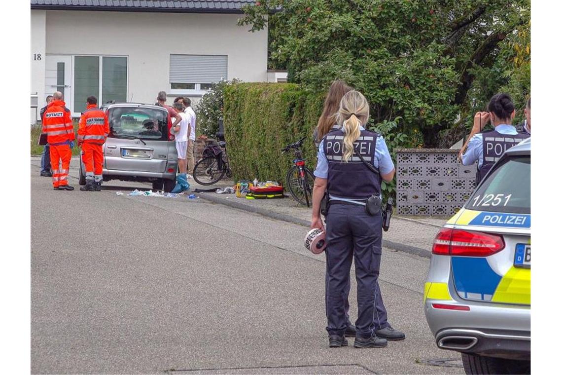 Polizisten sperren eine Straße ab, in der Rettungssanitäter neben einem PKW stehen. Foto: Fabian Geier/dpa/Archivbild