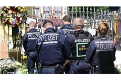 Polizisten stehen auf dem Marktplatz vor einem Gedenkplatz für einen bei einer Messerattacke getöteten Polizisten. Die Mannheimer Polizei plant eine öffentliche Trauerfeier.