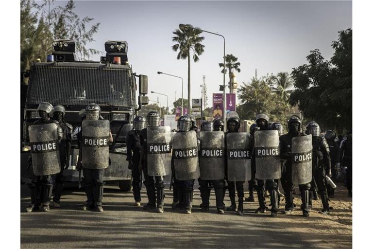 Polizisten stehen bei Protesten gegen die Ergebnisse der Präsidentenwahl in Gambia auf der Straße. Foto: Sally Hayden/SOPA Images via ZUMA Press Wire/dpa/Archiv