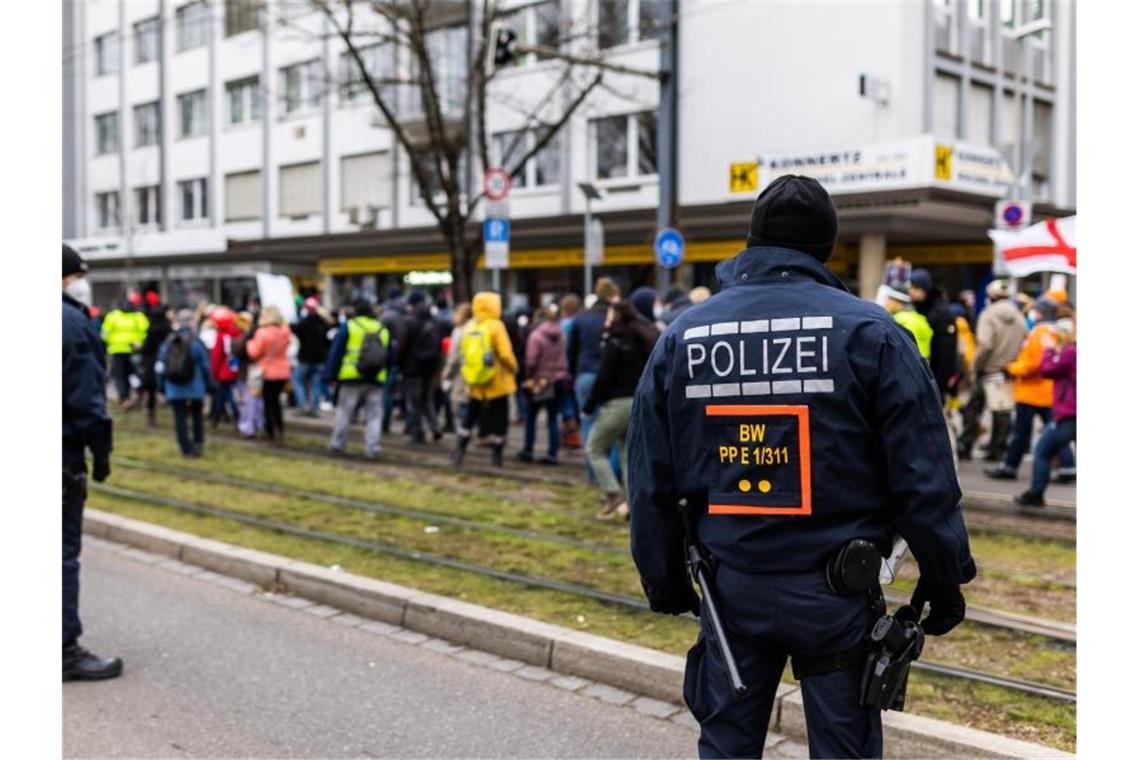 Polizisten stehen neben Teilnehmern einer Demonstration gegen die Corona-Maßnahmen. Foto: Philipp von Ditfurth/dpa/Archivbild