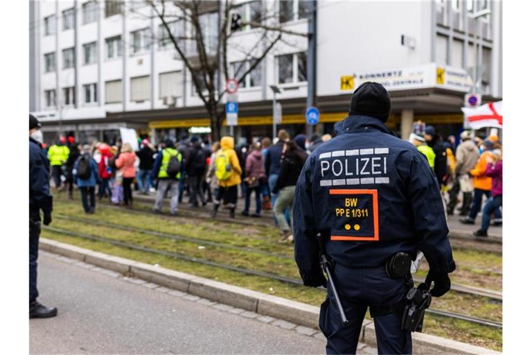 Polizisten stehen neben Teilnehmern einer Demonstration gegen die Corona-Maßnahmen. Foto: Philipp von Ditfurth/dpa/Archivbild