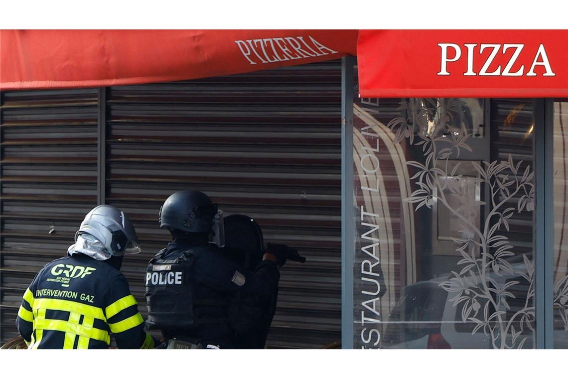 Polizisten stehen vor dem Restaurant in Issy-les-Moulineaux.