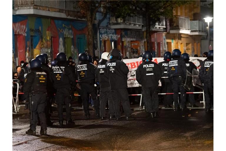 Polizisten stehen vor Demonstranten, die gegen die Räumung des besetzten Hauses „Liebig 34“ protestieren. Foto: Paul Zinken/dpa