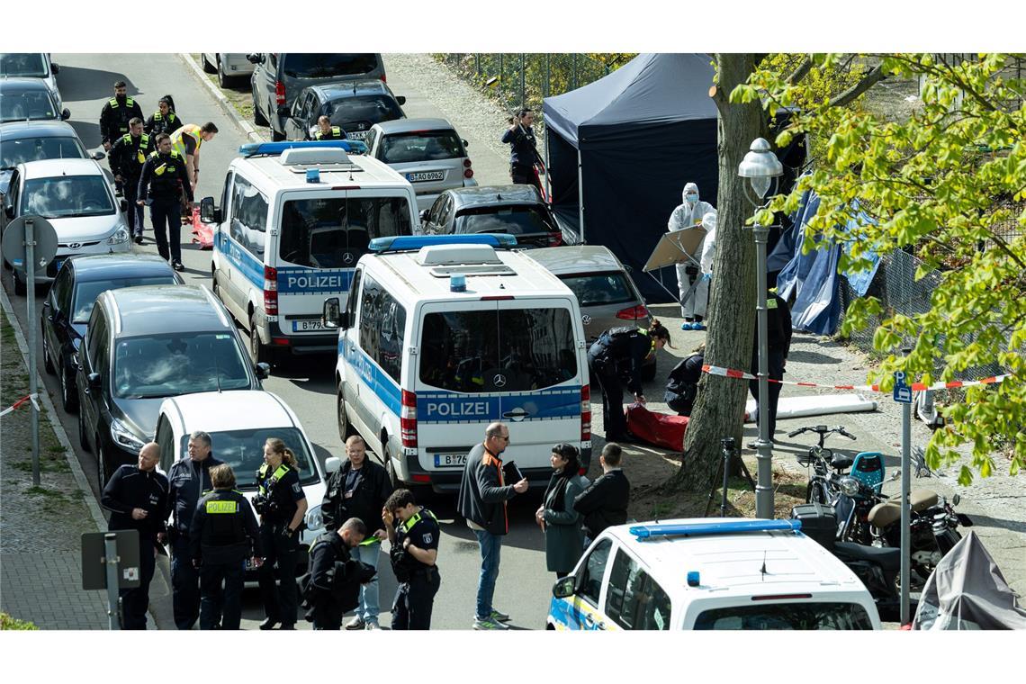 Mann in Berlin auf Gehweg getötet - Handwerker im Fokus Polizisten und Beamte der Spurensicherung in weißen Schutzanzügen stehen an dem Ort, wo ein toter Mann gefunden wurde.