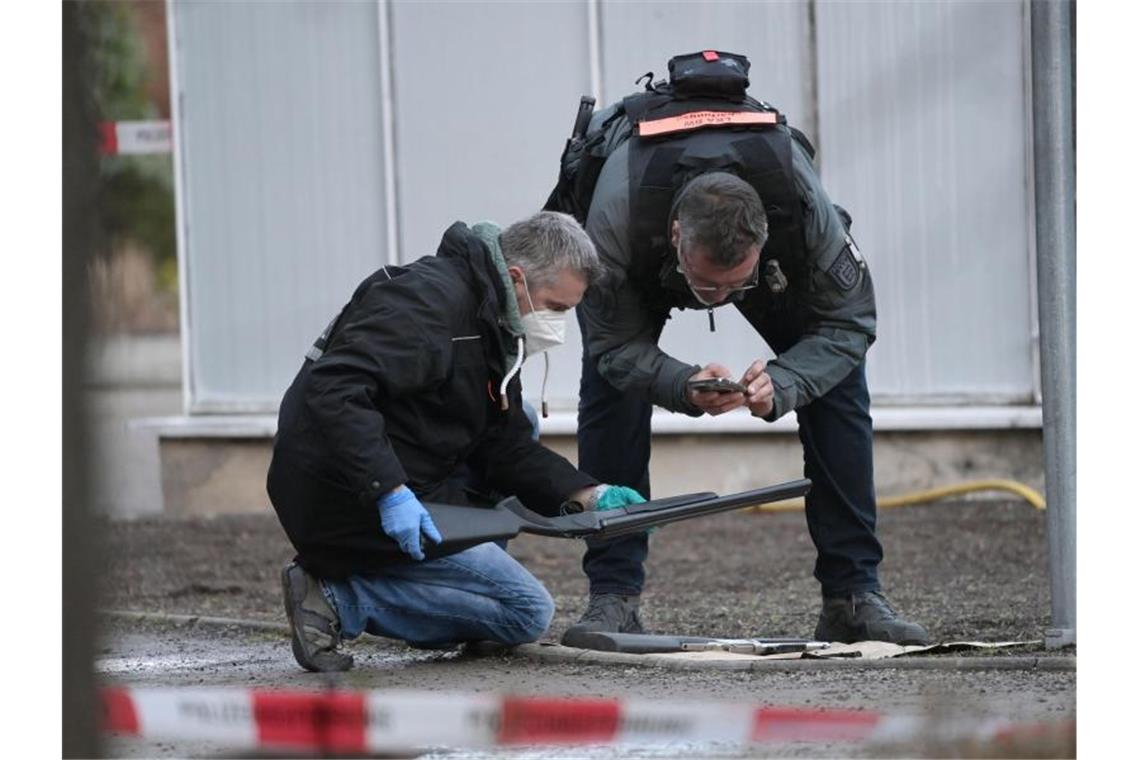 Polizisten untersuchen eine Waffe auf dem Gelände der Universität Heidelberg. Foto: Sebastian Gollnow/dpa