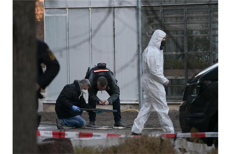 Polizisten untersuchen eine Waffe auf dem Gelände der Heidelberger Universität. Foto: Sebastian Gollnow/dpa