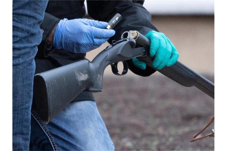 Polizisten untersuchen eine Waffe auf dem Gelände der Heidelberger Universität. Foto: Sebastian Gollnow/dpa