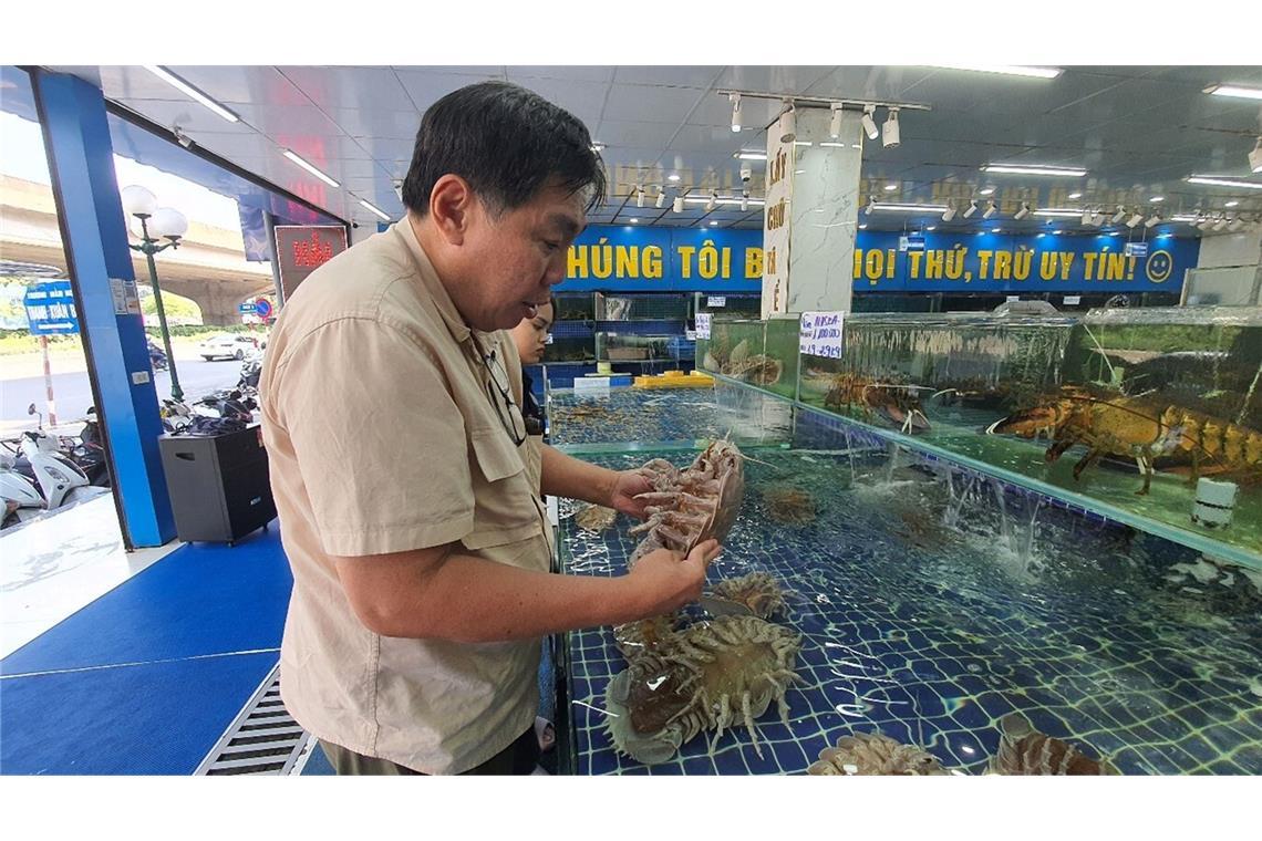 Professor Peter Ng untersucht Riesenasseln auf einem Fischmarkt in Hanoi in Vietnam.