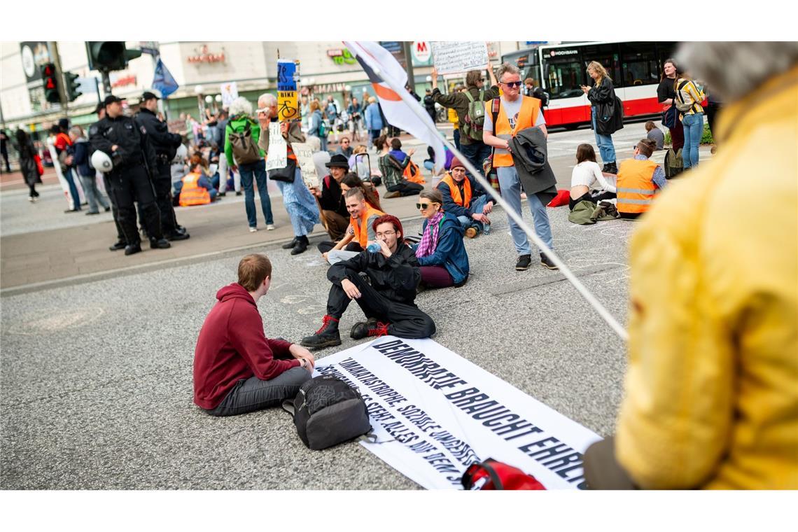 Protest im Sitzen: Aktivisten der "Letzten Generation" blockieren den Verkehr auf einer Straße in Hamburg. Bundesweit kündigte die Gruppe Proteste gegen die Umweltpolitik der Bundesregierung an.