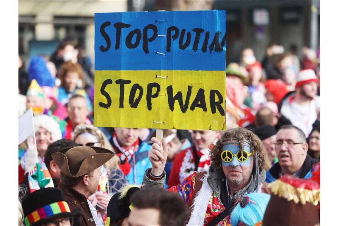 Protestplakat gegen den Krieg beim Kölner Straßenkarneval. Foto: Oliver Berg/dpa