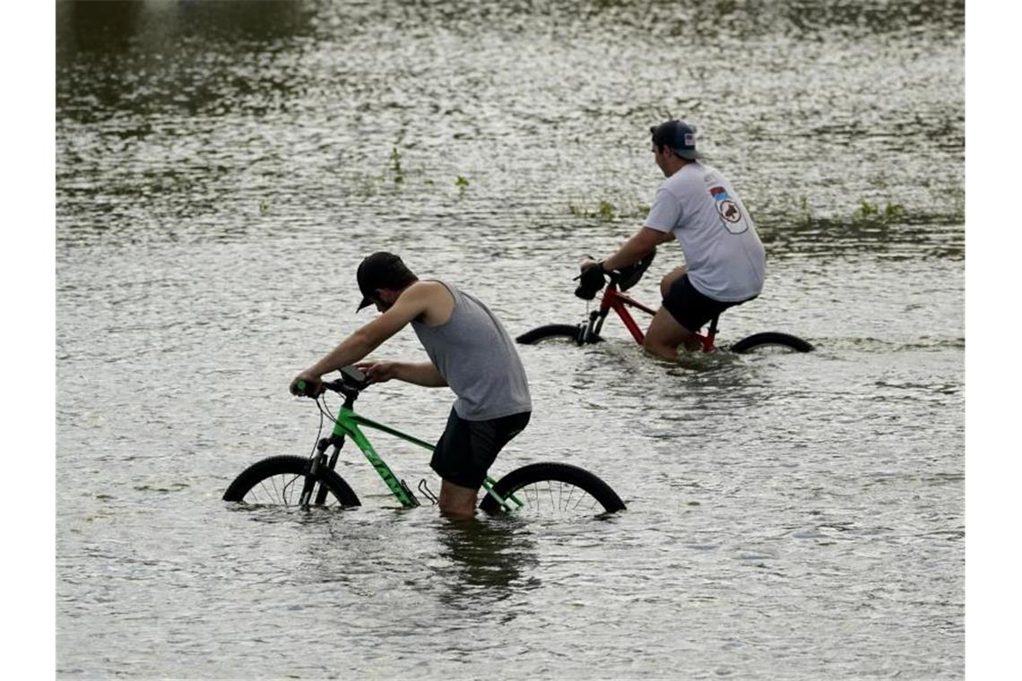 Eine Million Menschen nach Hurrikan „Ida“ ohne Strom Radfahrer radeln durch die Überschwemmungen des Hurrikans „Ida“ in der Nähe des Yachthafens von New Orleans. Foto: Eric Gay/AP/dpa