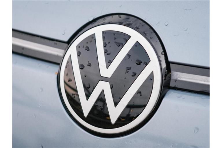 Regentropfen sammeln sich auf einem Volkswagen Logo. Foto: Ole Spata/dpa/Archivbild