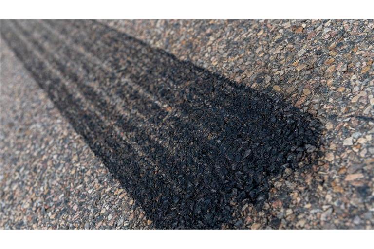 Reifenabrieb eines Auto auf einer Straße: Die Reifen enthalten  chemische Zusatzstoffe, die Hunderte von Substanzen umfassen.