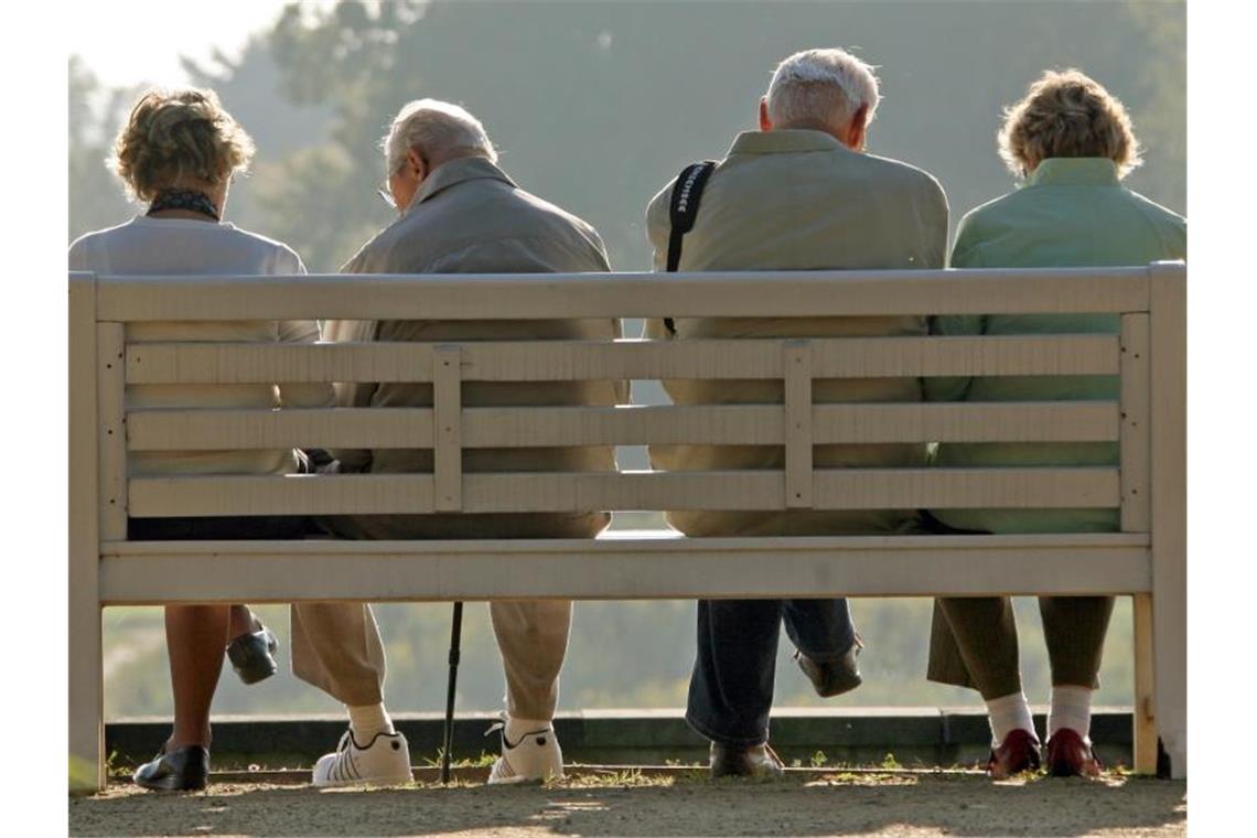 Rentner sitzen auf einer Parkbank. Foto: Ralf Hirschberger/zb/dpa