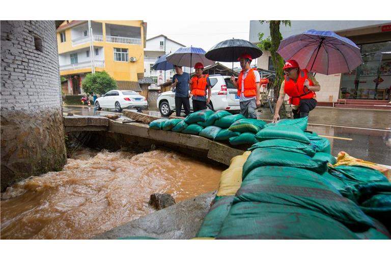 Rettungskräfte inspizieren einen Entwässerungskanal. Tagelange schwere Regenfälle haben in vielen Teilen der chinesischen Provinz Fujian, die wegen der Unwetter den Notstand ausgerufen hat, Verwüstungen angerichtet.