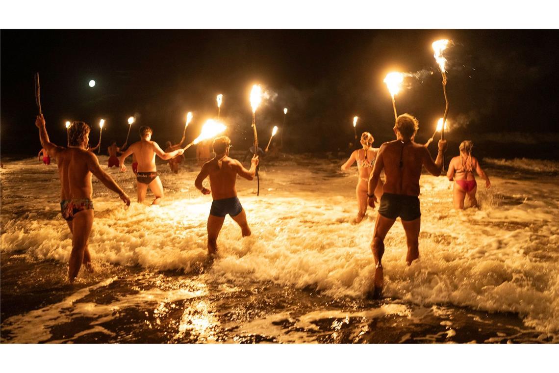 Rettungsschwimmer in Mar Azul, Argentinien, waten mit Fackeln in den Atlantik, um den Tag der Rettungsschwimmer zu begehen.