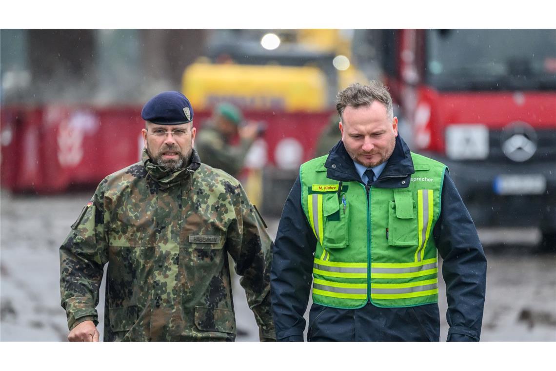 Robert Habermann (l), Oberstleutnant der Bundeswehr, und Michael Klahre, Sprecher der Feuerwehr Dresden, am Elbufer nahe der eingestürzten Carolabrücke.