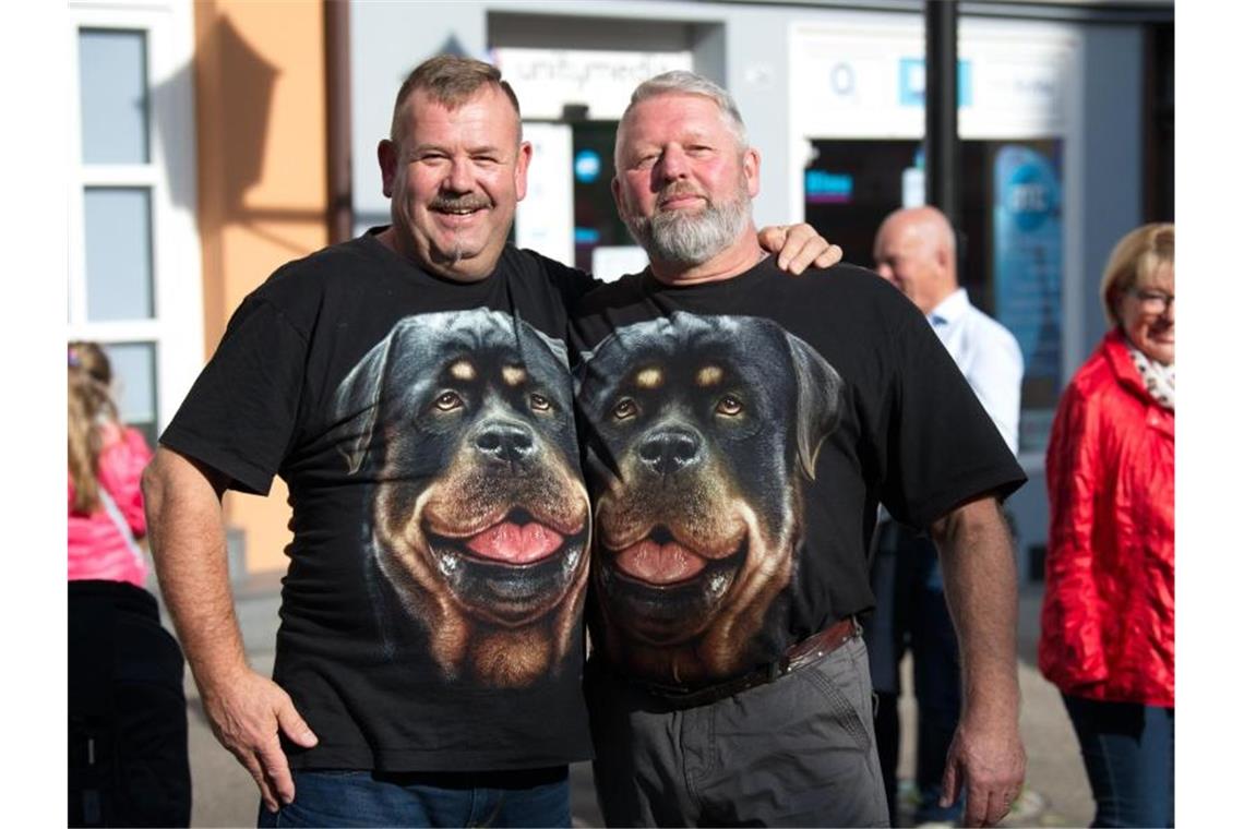 Rolf (l.) und Michael tragen T-Shirts, auf denen Hundeköpfe von Rottweilern abgebildet sind. Foto: Ralf Graner/dpa