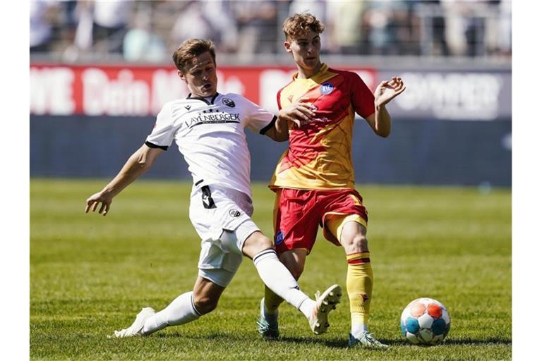 Sandhausens Carlo Sickinger (l) und Karlsruhes Dominik Kother kämpfen um den Ball. Foto: Uwe Anspach/dpa