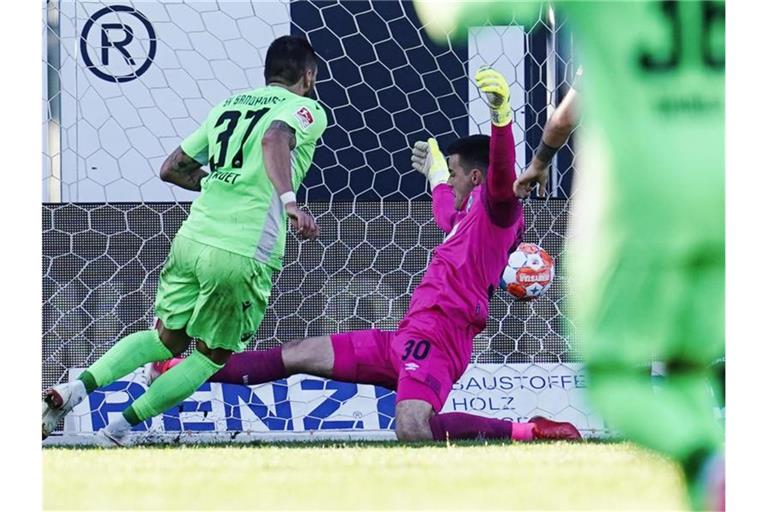 Sandhausens Pascal Testroet (l) schiesst an Bremens Torwart Michael Zetterer vorbei das Tor zum 2:1. Foto: Uwe Anspach/dpa